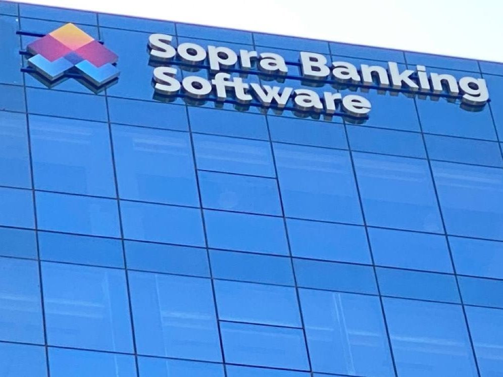Corporate identity mounted high on a glazed office elevation, sized to read from the approach road.
