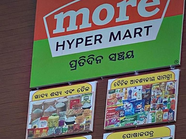 Retail fascia in ACP carrying the store identity above printed category panels, built for a high-footfall hypermarket frontage.