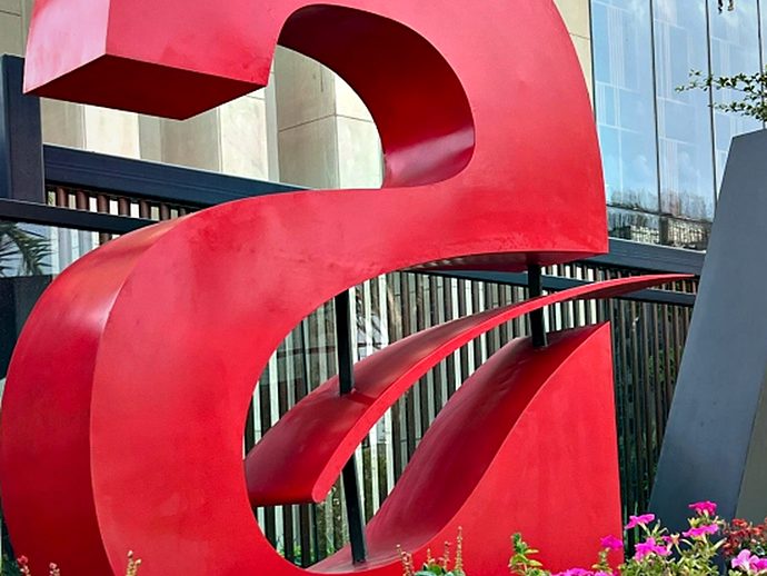 Detail of an oversized dimensional letter on a landscaped plinth — the depth of the return is what gives a letter this size its presence.