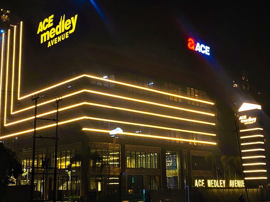Warm linear lighting tracing the full building profile, coordinated with the rooftop and fascia signage.