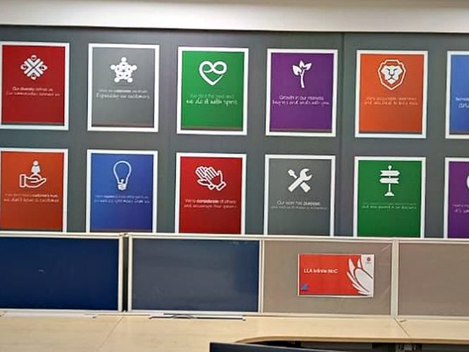 A grid of individually framed value panels forming a single composition down the length of a workspace wall.