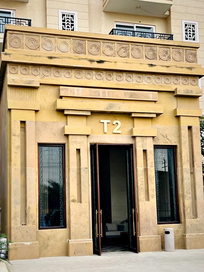 Tower identification carved into a classical stone entrance portal so the signage and the architecture read as one element.