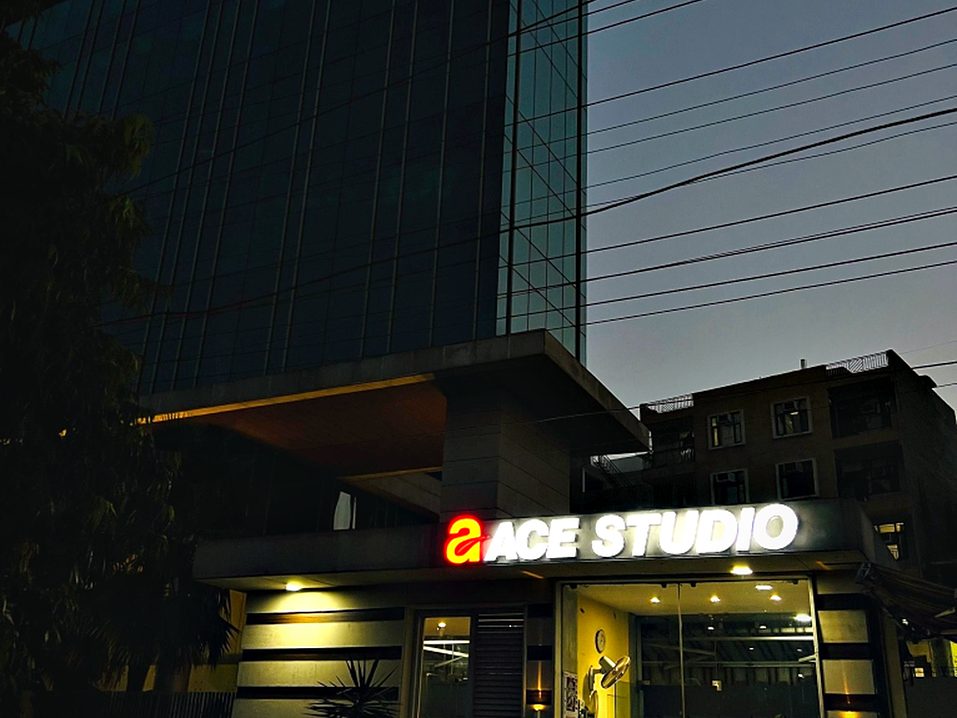 Illuminated studio frontage at dusk, when a sales gallery does most of its walk-in business.