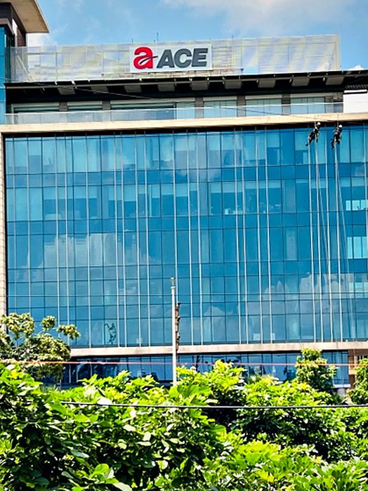 Rooftop brand signage on a glazed office tower, carried on a galvanised frame above the parapet line.